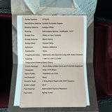 Technical specifications sheet for a guitar on a wooden surface