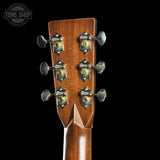 Close-up of a guitar headstock with tuning pegs on a black background, featuring the Tone Shop logo.
