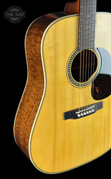 Acoustic guitar with a visible brand logo on a black background