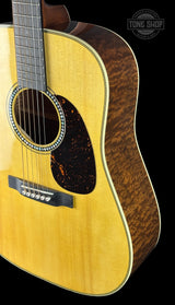 Acoustic guitar with a visible brand logo on a black background