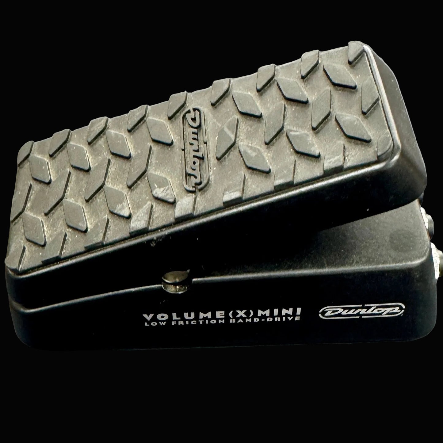 Black Dunlop volume pedal with textured top on a gray background
