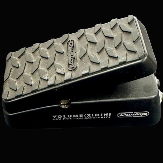 Black Dunlop volume pedal with textured top on a gray background