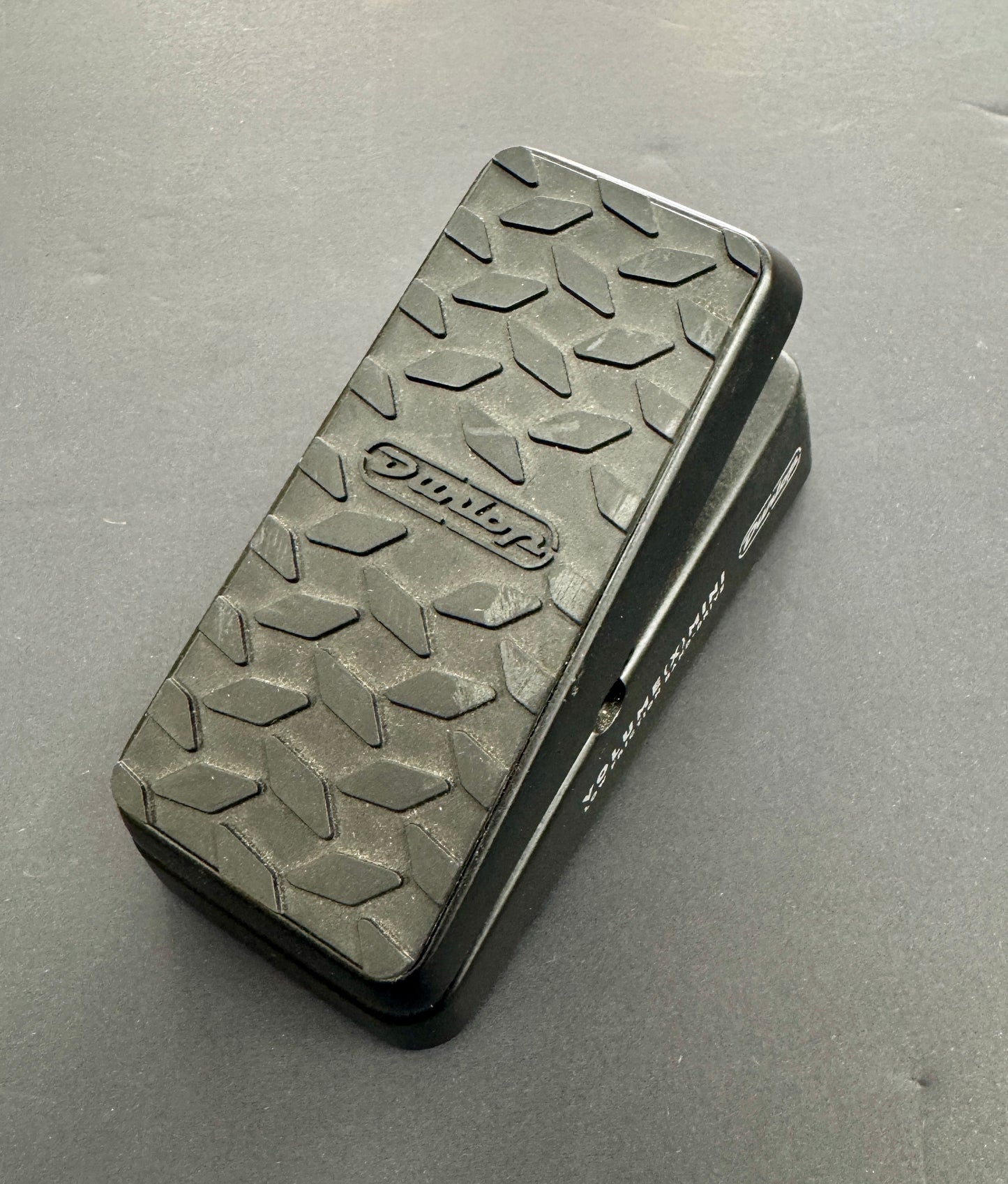Black guitar effects pedal with textured surface on a gray background