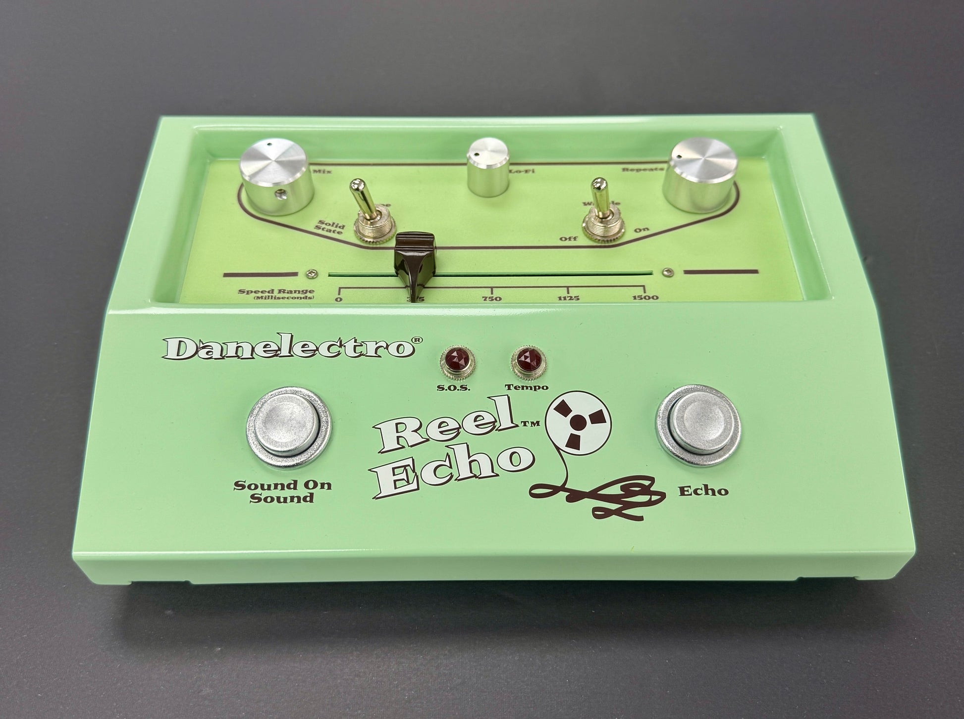 Green electronic pedal with 'Danelectro Reel Echo' branding on a gray background