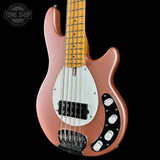 Pink electric bass guitar with a white pickguard on a black background, featuring 'Tone Shop' branding.