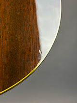 Close-up of a glossy brown wooden surface with a curved edge and a thin gold-toned trim against a gray background.