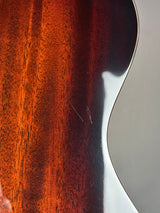 Close-up of a glossy reddish-brown wooden surface with a curved white highlight and visible wood grain texture.