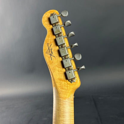 Guitar headstock with tuning pegs on a dark gray background