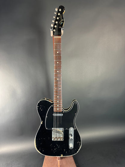 Black electric guitar on a gray background