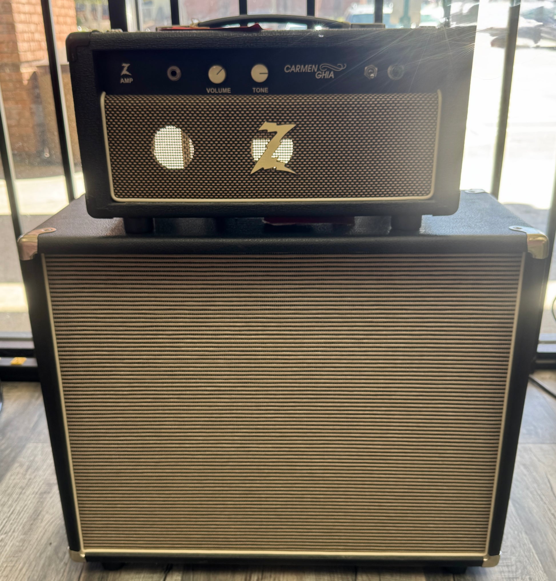 Guitar amplifier with 'Carmen USA' branding on a wooden surface.
