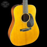 Acoustic guitar with a visible brand logo on a black background