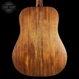 Close-up of a wooden acoustic guitar back with 'Tone Shop' logo.