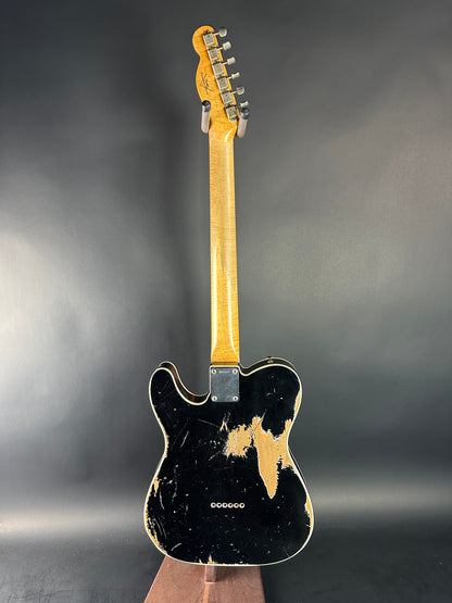 Electric guitar with a black finish on a gray background
