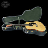 Acoustic guitar in a hard case with 'Tone Shop' logo in the corner.