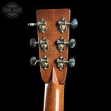 Close-up of a guitar headstock with tuning pegs on a black background, featuring the Tone Shop logo.