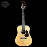 Acoustic guitar with a visible brand logo on a black background