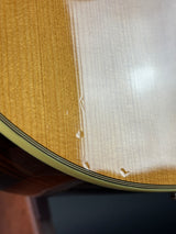 Close-up of a wooden instrument body showing the glossy varnish, wood grain, and part of the dark rim.
