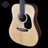 Acoustic guitar with a visible brand logo on a black background