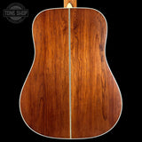Back view of a wooden acoustic guitar with 'Tone Shop' logo.