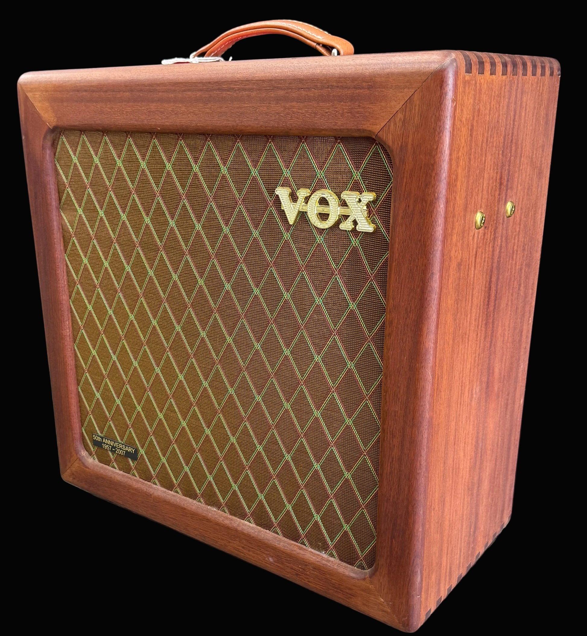 Wooden VOX amplifier on a wooden floor with a dark background