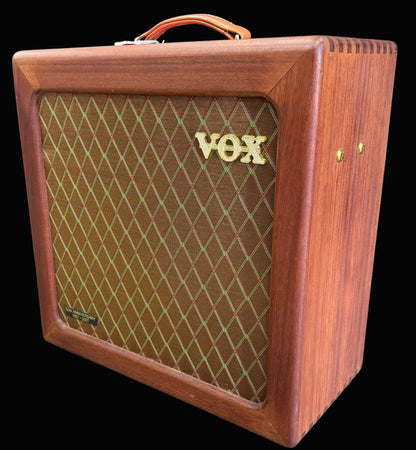 Wooden VOX amplifier on a wooden floor with a dark background