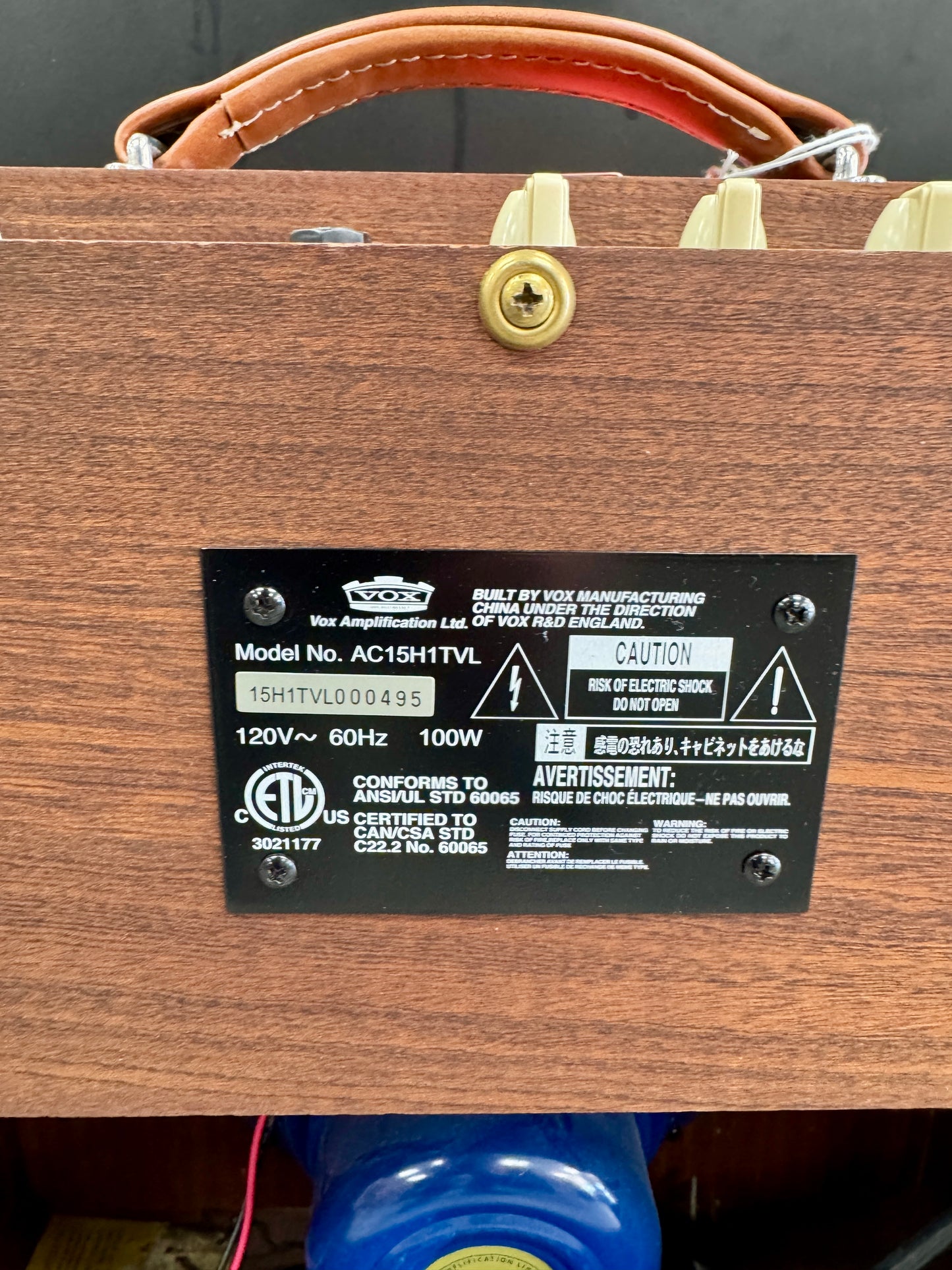 Wooden amplifier with a label on a dark background