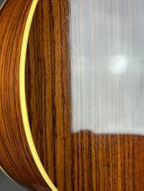 Close-up detail of a glossy dark brown wood surface with visible grain and a light-colored edge trim.