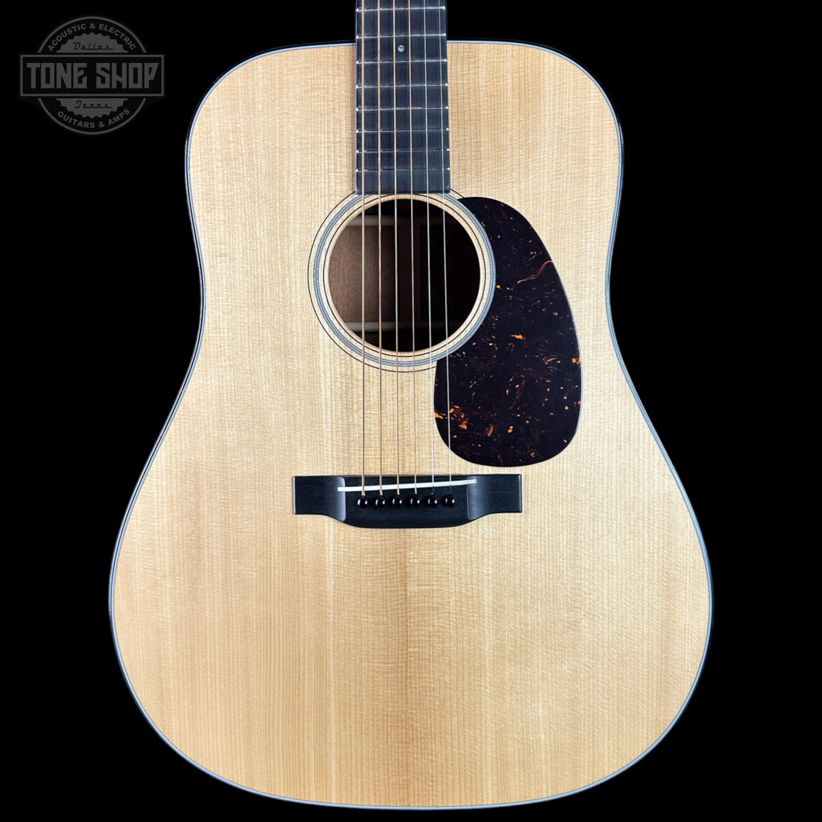 Acoustic guitar with a visible brand logo on a black background