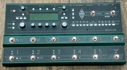 Guitar effects pedal with multiple controls and displays on a wooden surface