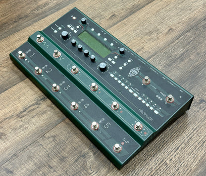 Green guitar effects pedal on a wooden surface