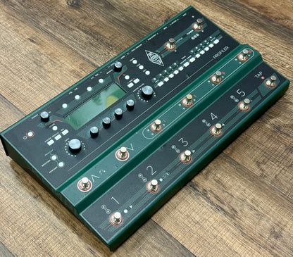 Green electronic pedal device on a wooden surface