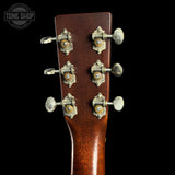 Close-up of a guitar headstock with tuning pegs on a black background, featuring the Tone Shop logo.