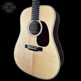 Acoustic guitar with a visible brand logo on a black background