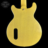 The back of a yellow-finish electric guitar body, shown against a solid black background with a Tone Shop watermark in the top-left corner.