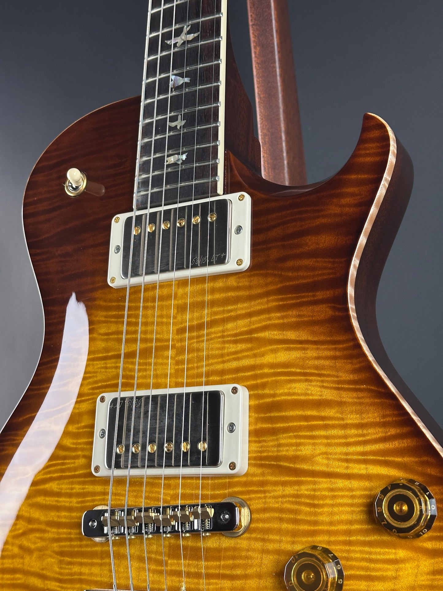 Close-up of a electric guitar with a sunburst finish on a dark background