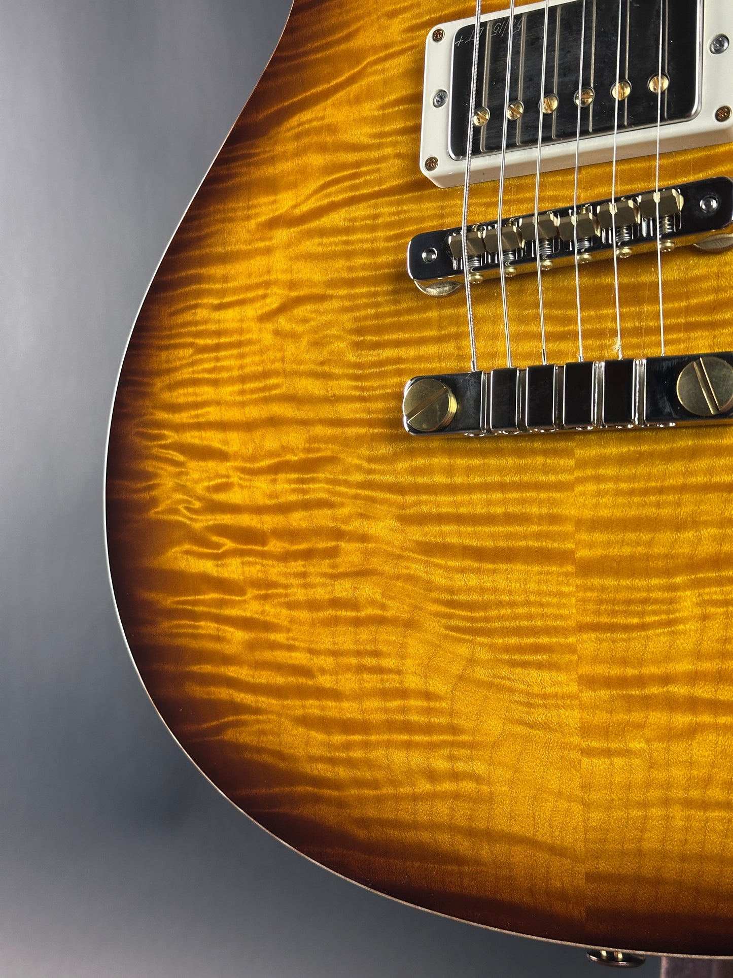 Close-up of a guitar's body with a focus on the wood grain and hardware.