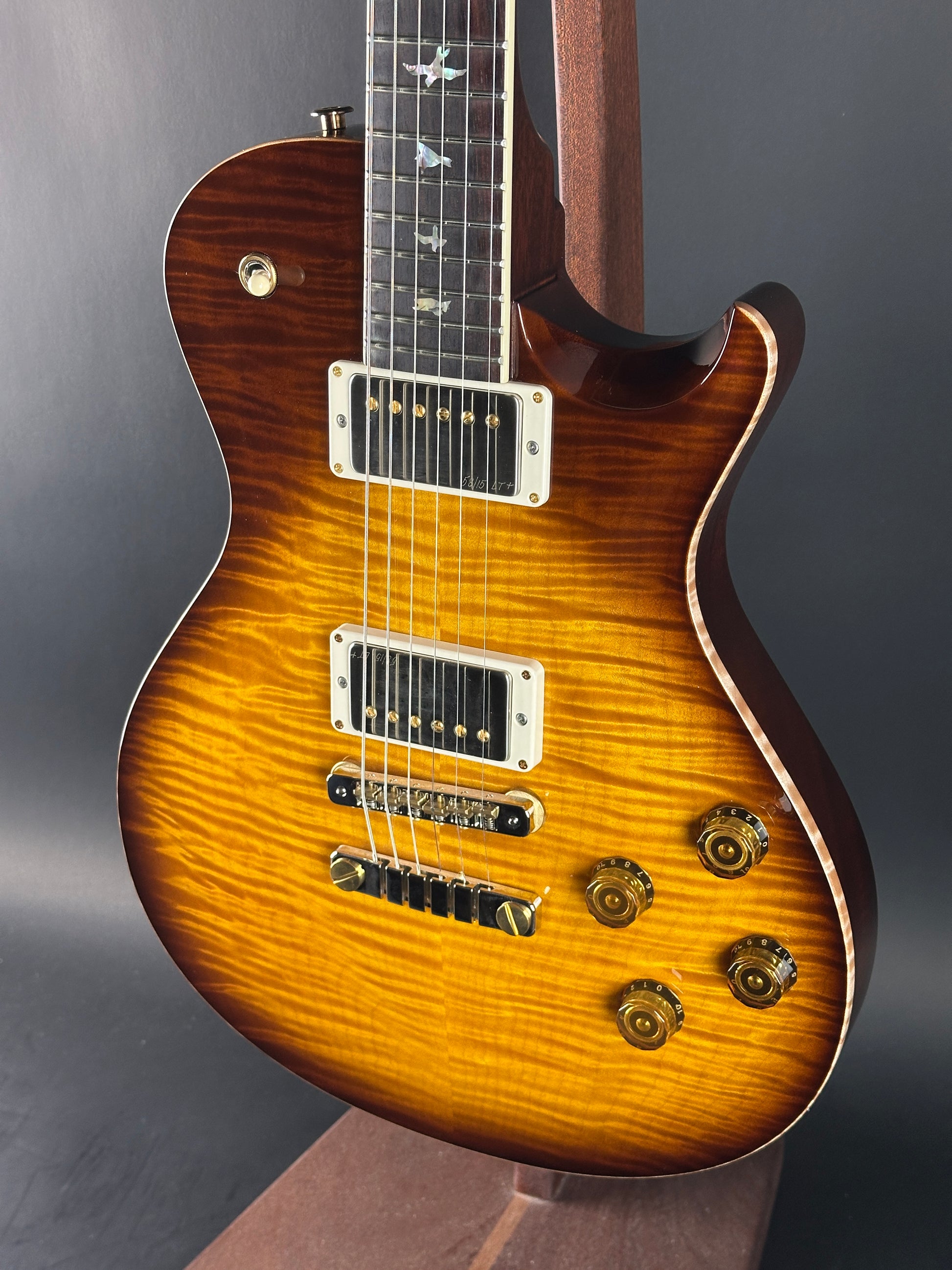 Close-up of a sunburst electric guitar on a dark background