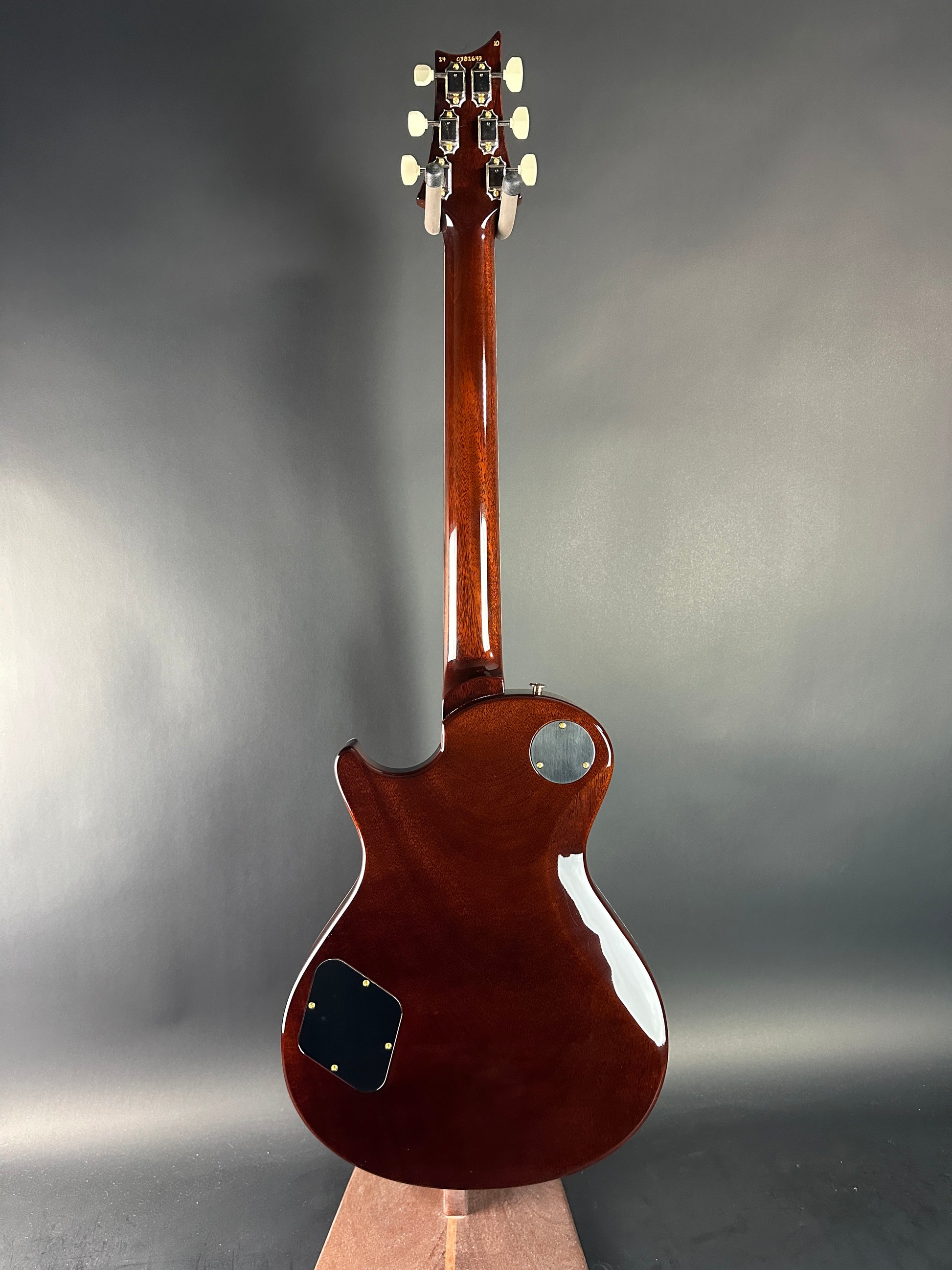 Glossy brown electric guitar on a gray background