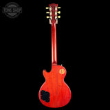 A red electric guitar shown from the back against a solid black background, with a Tone Shop watermark in the upper left corner.