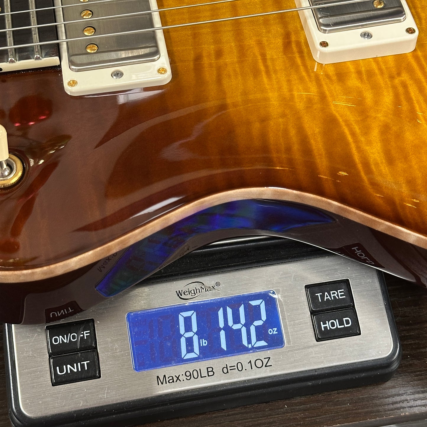 Guitar on a digital scale displaying weight