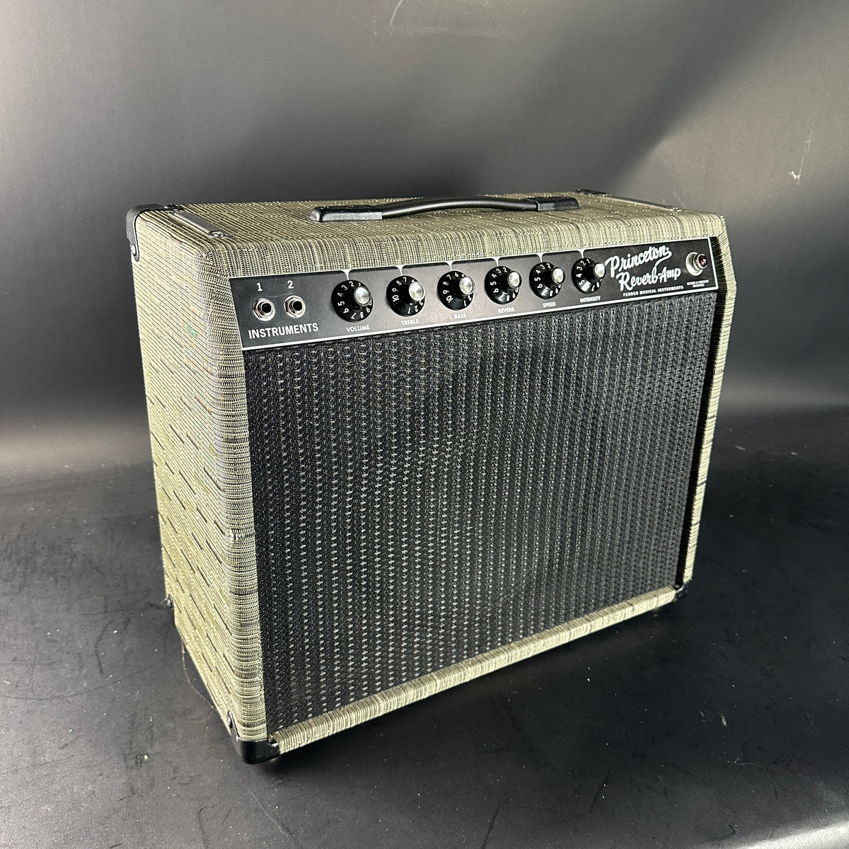 Guitar amplifier with wicker design on a dark background
