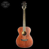 A wooden acoustic guitar with a warm reddish-brown finish, shown vertically against a solid black background. A circular 'TONE SHOP' watermark is visible in the top-left corner.