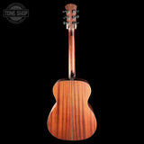 An acoustic guitar shown from the back, featuring a rich reddish-brown wood grain finish on the body and neck, set against a solid black background with a Tone Shop watermark in the top-left corner.