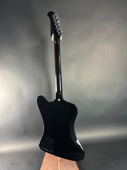 Black electric guitar on a gray surface