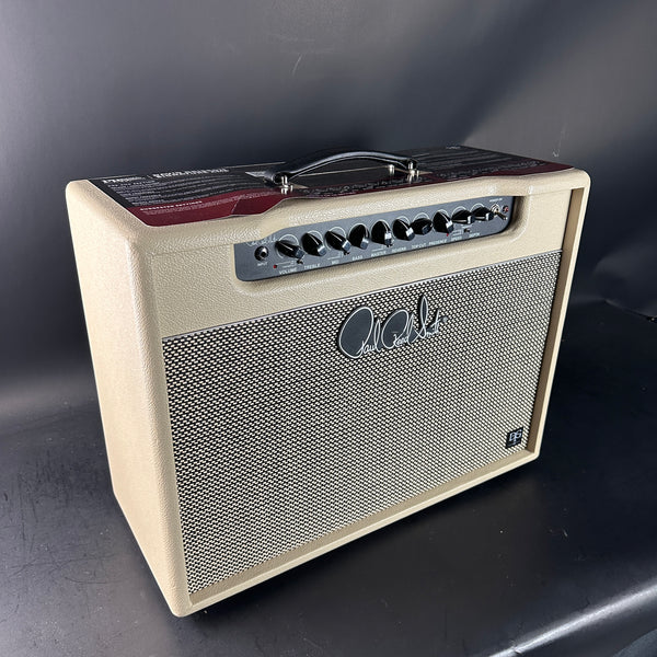 Beige guitar amplifier with 'PRS' branding on a dark background