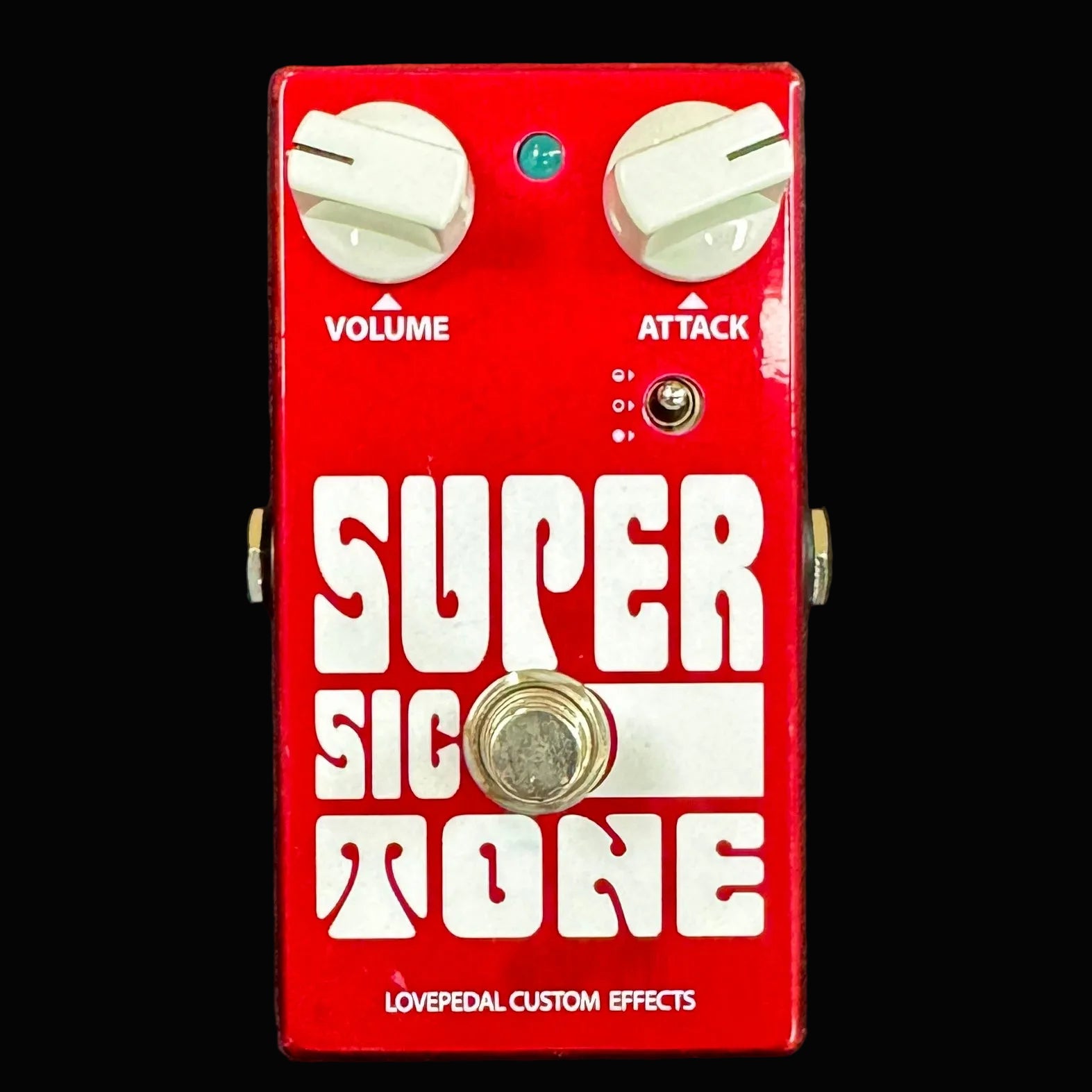 Red guitar effects pedal with 'Super Sic Tone' branding on a dark background