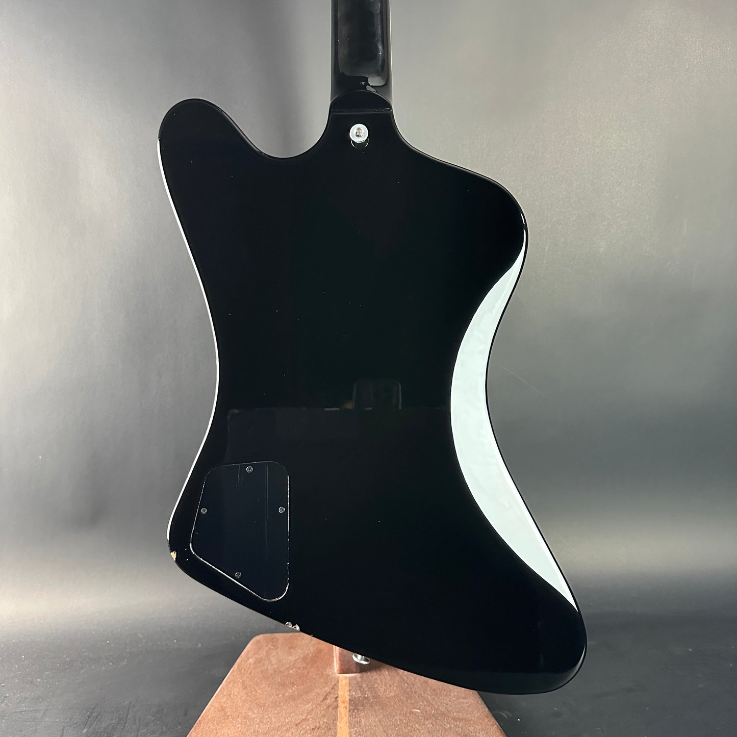 Black electric guitar body on a gray background