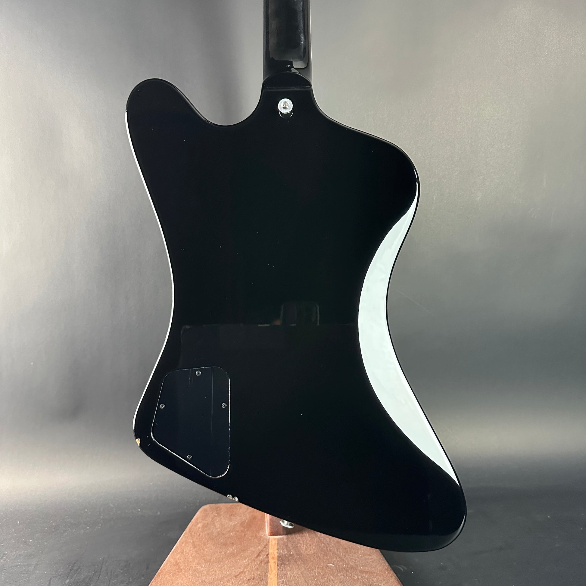 Black electric guitar body on a gray background