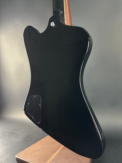 Black electric guitar body on a gray surface