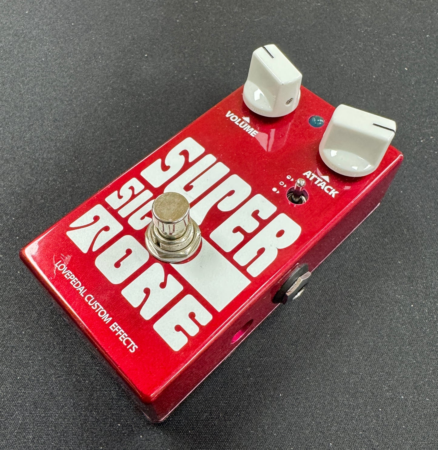 Red guitar effects pedal with white text on a gray background